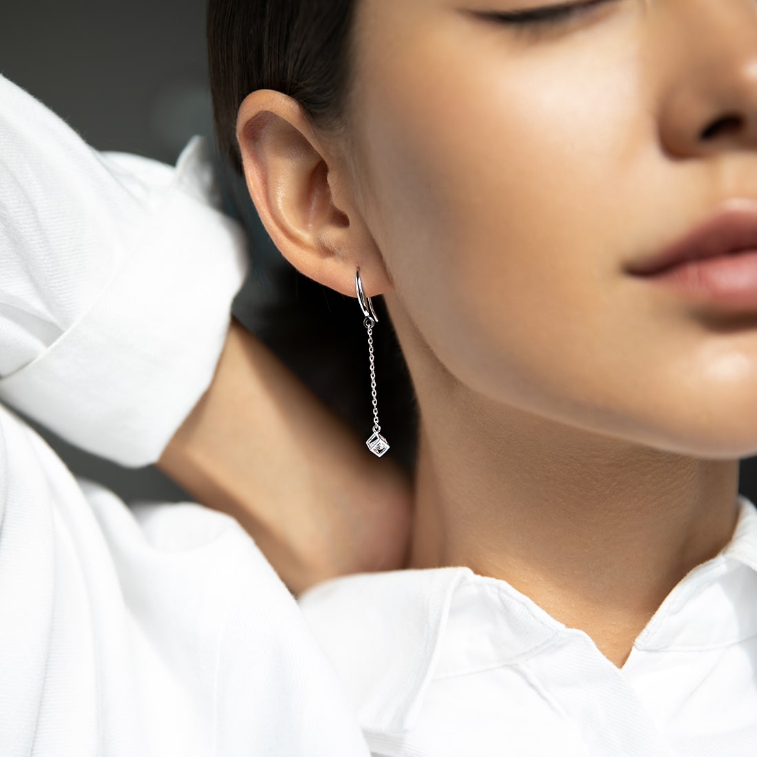 Earrings with a cubic zirconia in a cube